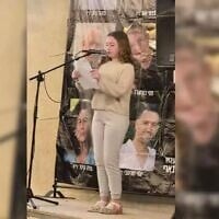 Former hostage Emily Hand speaks on May 21, 2025, at a Kibbutz Be'eri rally held for the hostages in the kibbutz's temporary quarters in Kibbutz Hazerim. (Courtesy Kibbutz Be'eri)